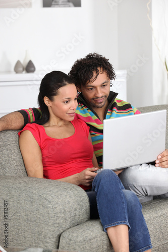 Photo: Couple looking at pictures on their laptop Couple looking at pictures on their laptop