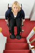 Junge Frau mit Rollstuhl vor Treppe