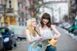 Two young beautiful women sightseeing and looking at the map in