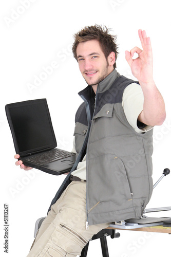 Photo: Tile cutter with laptop making OK gesture Tile cutter with laptop making OK gesture