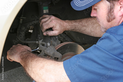 Photo: Auto Mechanic Works on Brakes Auto Mechanic Works on Brakes