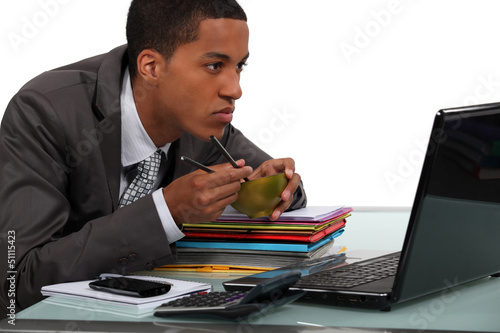 Photo: Man eating Chinese food at a laptop Man eating Chinese food at a laptop