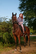 woman with red hair sitting on a horse