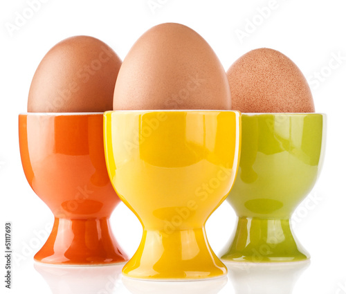Photo: Eggs in color stand isolated on white background Eggs in color stand isolated on white background