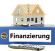 Schriftzug Finanzierung auf Kladde mit Rohbau