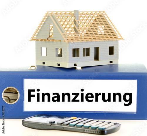 Photo: Schriftzug Finanzierung auf Kladde mit Rohbau Schriftzug Finanzierung auf Kladde mit Rohbau