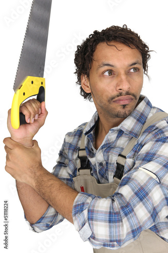Photo: Scared carpenter holding hand-saw Scared carpenter holding hand-saw