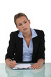 Photo: Blond woman sat at desk with blank clip-board Blond woman sat at desk with blank clip-board