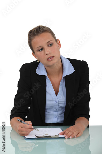 Photo: Blond woman sat at desk with blank clip-board Blond woman sat at desk with blank clip-board