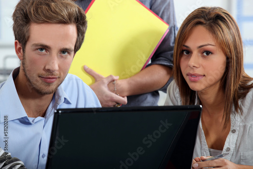 Photo: Interns sitting at a desk with computer Interns sitting at a desk with computer