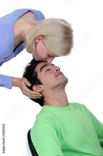 Photo: Woman kissing boyfriend on forehead Woman kissing boyfriend on forehead