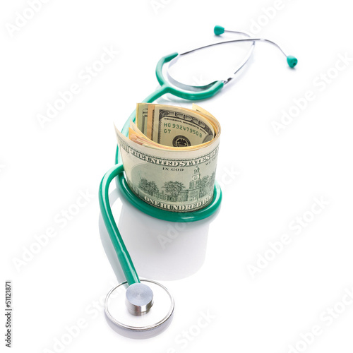 Photo: Doctor stethoscope with cash in dollars over white Doctor stethoscope with cash in dollars over white