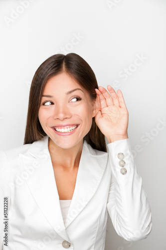 Photo: Business woman listening with hand to ear concept Business woman listening with hand to ear concept
