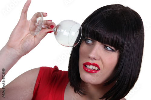 Photo: Woman checking empty wine glass Woman checking empty wine glass