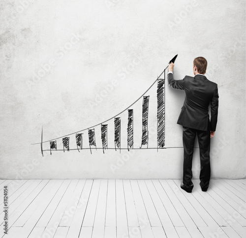 Photo: businessman drawing up arrow on the wall businessman drawing up arrow on the wall