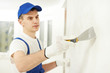 Photo: Plasterer with putty knife at wall filling Plasterer with putty knife at wall filling