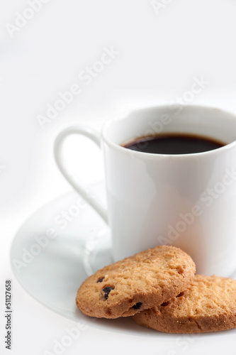 Photo: A cup of coffee with some cookies on white background A cup of coffee with some cookies on white background