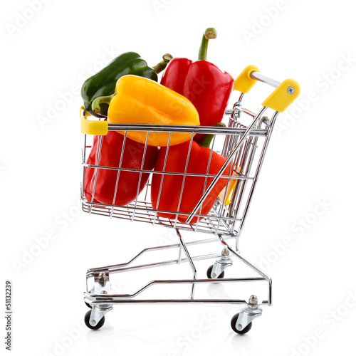 Photo: Shopping trolley full of pepper on white background Shopping trolley full of pepper on white background