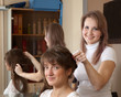  hairdresser works on woman hair