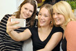 Junge Frauen fotografieren sich mit Smartphone