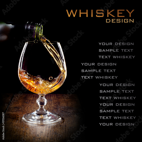 Photo: Cognac glass and bottle on a black Cognac glass and bottle on a black
