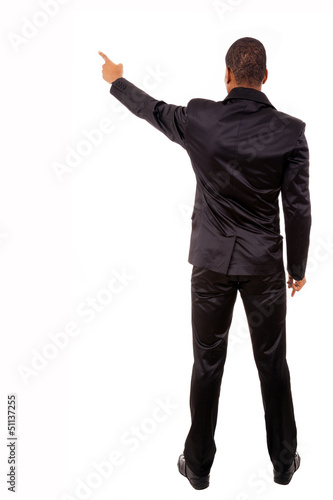 Photo: Full length of a African business man pointing at copyspace isol Full length of a African business man pointing at copyspace isol