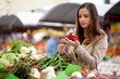 Young woman buying red hot chilli peppers at the market