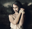 Dark horror scene of an evil zombie woman tied up