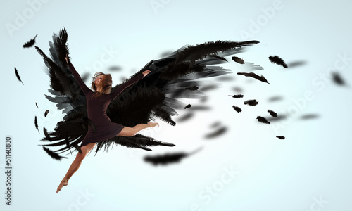 Photo: Woman floating on dark wings Woman floating on dark wings