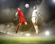 two football players striking the ball