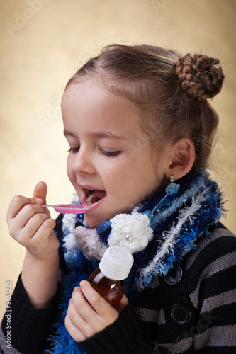 Photo: Young girl taking cough medicine Young girl taking cough medicine