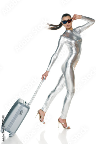 Photo: Futuristic woman in silver clothing and 3D glasses with suitcase Futuristic woman in silver clothing and 3D glasses with suitcase