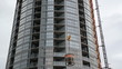 Concrete being lifted up by tower crane. Condo construction.