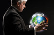 Senior business man holding planet in his arms and controlling i
