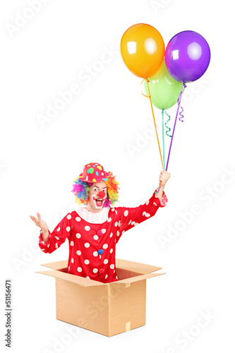 Photo: A clown in a cardboard box holding balloons A clown in a cardboard box holding balloons