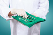 Closeup of dentist hand taking mirror from on of dental tools.