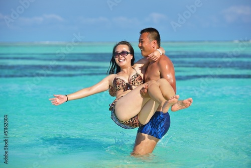 Photo: happy young couple enjoying summer on beach happy young couple enjoying summer on beach