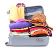 Open silver suitcase with clothing isolated on white
