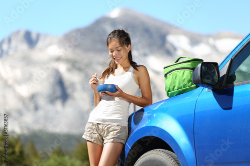 Photo: Car road trip woman eating in Yosemite Park Car road trip woman eating in Yosemite Park