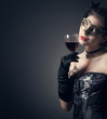 woman in carnival mask and a glass of red wine.