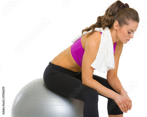 Photo: Tired fitness young woman sitting on fitness ball Tired fitness young woman sitting on fitness ball