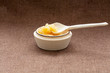 Pot of honey and wooden dipper on a cloth