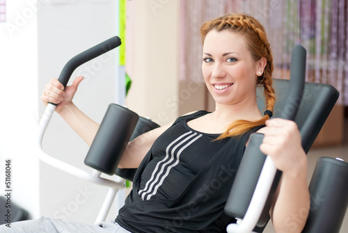 Photo: Cute young happy smiling woman doing fitness exercesing Cute young happy smiling woman doing fitness exercesing