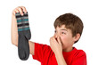 Junge mit stinkenden Socken hält sich die Nase zu