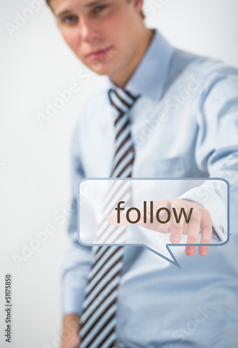Photo: Handsome businessman pressing on follow button Handsome businessman pressing on follow button