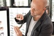Middle-aged man choosing sunglasses in a shop