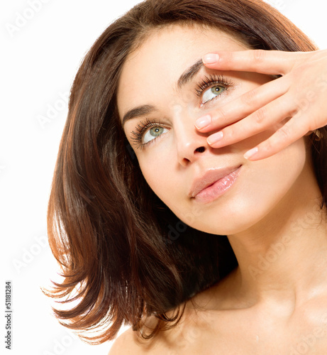Photo: Beautiful Young Woman touching Her Skin. Portrait over White Beautiful Young Woman touching Her Skin. Portrait over White