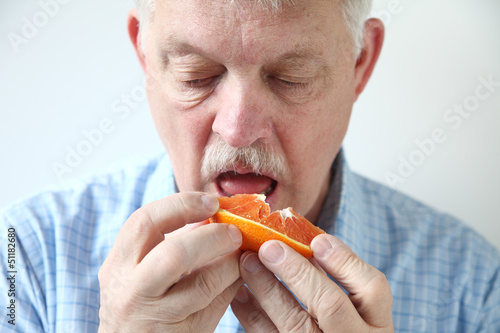 Photo: older man eating orange older man eating orange