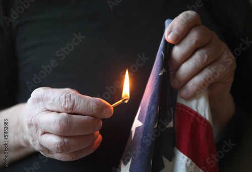 Photo: holding match to American flag holding match to American flag