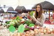 Young woman buying vegetables at the market